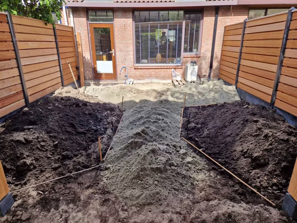 Voorbereiding van het terras in Ommoord met verdeeld zand en uitgezette lijnen door de hovenier.