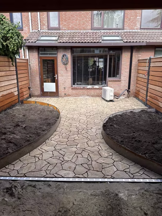 Overzicht van afgewerkt terras met geplaatste Cortenstaal borders richting het huis.